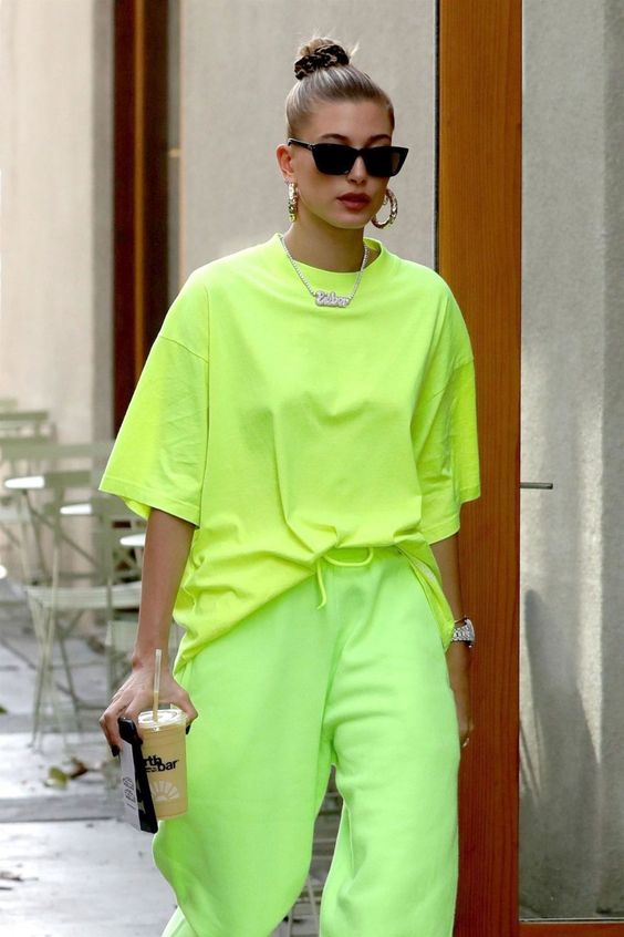 Hailey Beiber; young millennial woman sporting a neon green; alien slime t-shirt and sweatpants