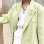 millennial woman wearing a white suit under a neon green trendy blazer